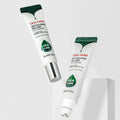 Dois tubos brancos do Cica Farm Revitalizing Rolling Eye Serum, com tampas verdes. Um tubo está na vertical e o outro inclinado, ambos sobre um fundo cinzento-claro.