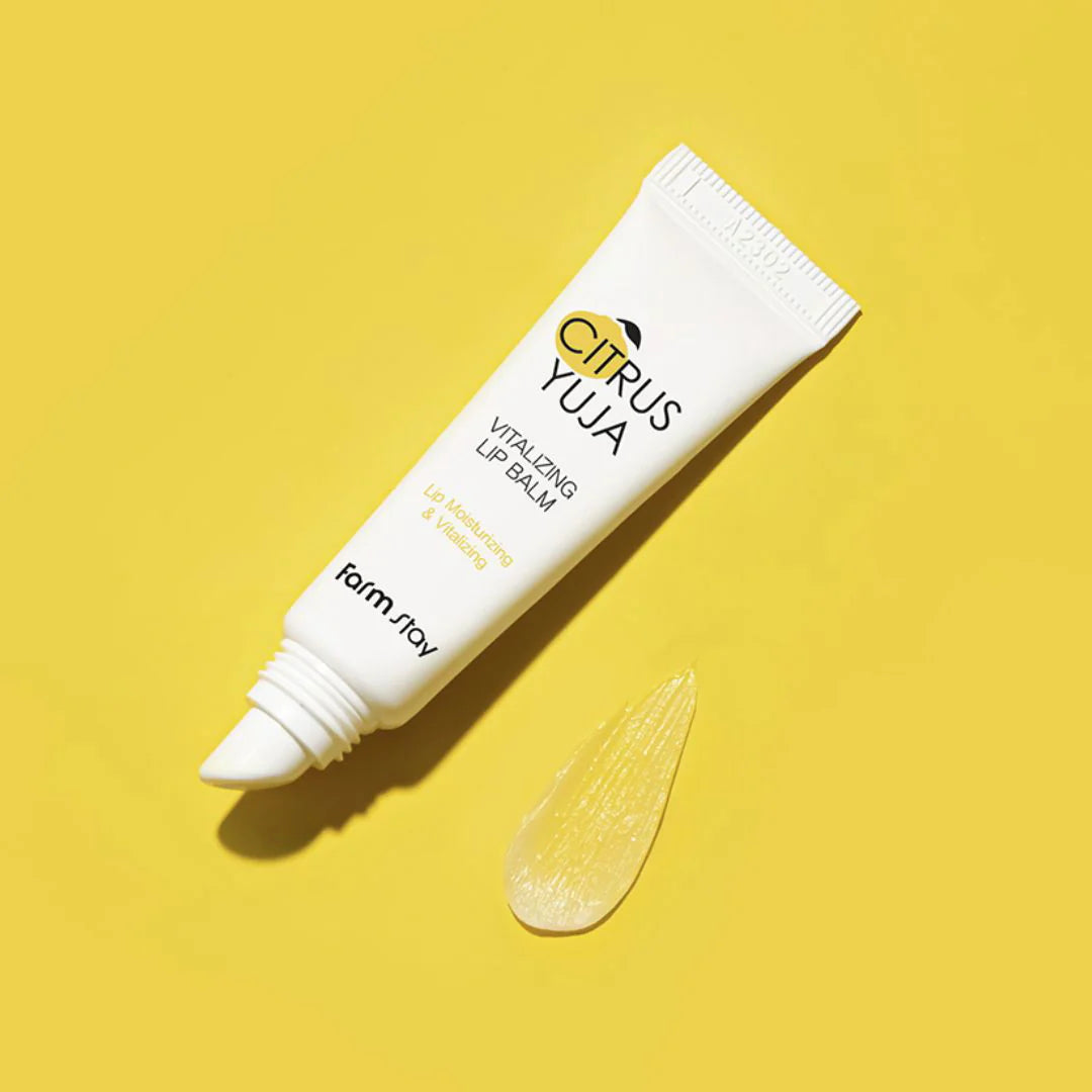 Citrus Yuja Vitalizing Lip Balm num tubo branco com tampa preta. A caixa e a embalagem apresentam um design branco e amarelo, destacando os benefícios de hidratação.
