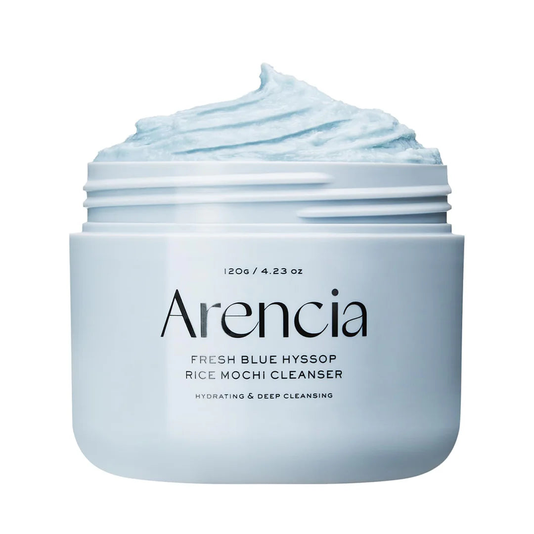 Um frasco do Arencia Fresh Blue Hyssop Rice Mochi Cleanser, aberto para revelar o creme azul-claro. O rótulo destaca os benefícios hidratantes e de limpeza profunda.