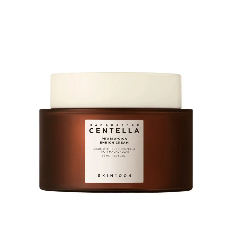 Frasco castanho com a inscrição “Madagascar Centella Probio-Cica Enrich Cream” e tampa branca, destacando o foco em cuidados de pele e ingredientes naturais. Design limpo e minimalista. Skin1004. Glowthie Portugal.
