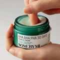 Creme facial coreano Some By Mi, pote verde, sendo aplicado com o dedo, skincare.