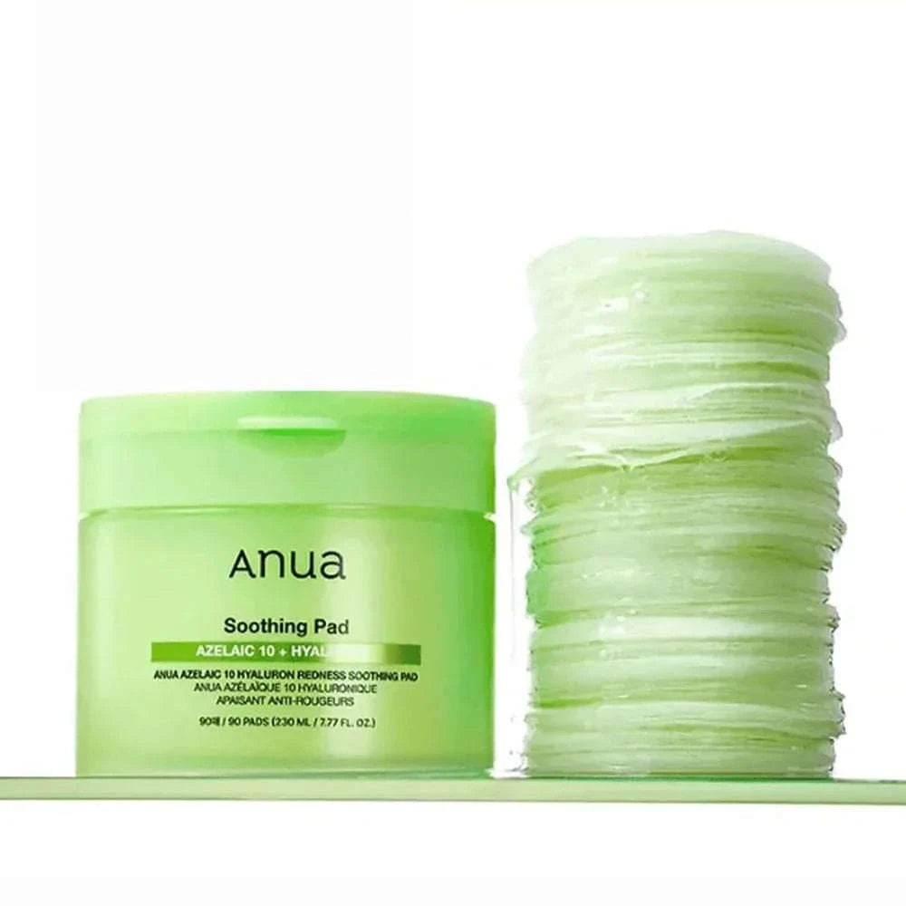 Um frasco cilíndrico verde-claro com a inscrição “Anua Soothing Pad” e “Azelaic 10 + Hyaluron” por baixo. Contém 90 discos, 230 ml, indicado para acalmar a vermelhidão. KBeauty Portugal.