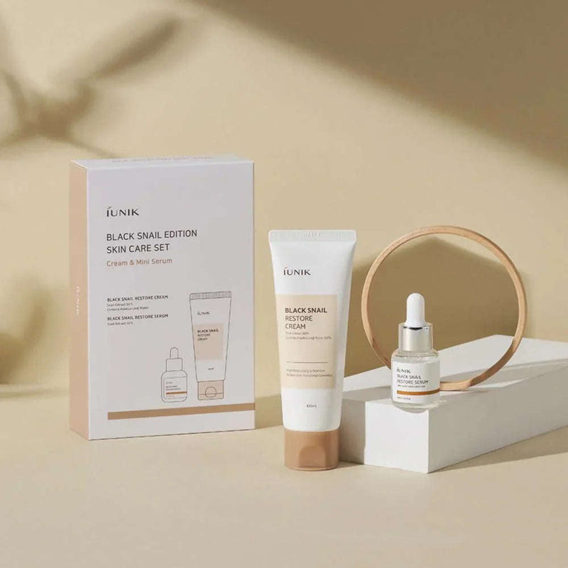 Conjunto de cuidados de pele coreano iUNIK Black Snail, com creme e mini sérum, em fundo bege.