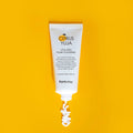 Tubo branco do Citrus Yuja Vitalizing Foam Cleanser sobre um fundo amarelo vibrante. Uma espiral de espuma emerge, transmitindo frescura e vitalidade.