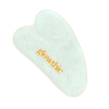Gua Sha em jade branca — beleza natural em cada gesto. Pedra sobre fundo branco.