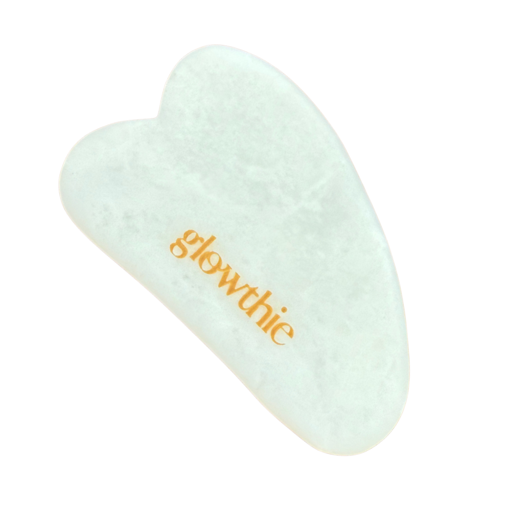 Gua Sha em jade branca — beleza natural em cada gesto. Pedra sobre fundo branco.