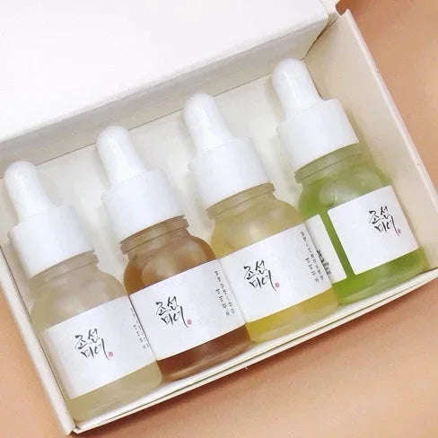 Kit de quatro séruns coreanos em frascos de vidro com conta-gotas, em embalagem branca.