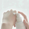 Aplicação de loção facial coreana hidratante na mão com pump branco, cuidado da pele