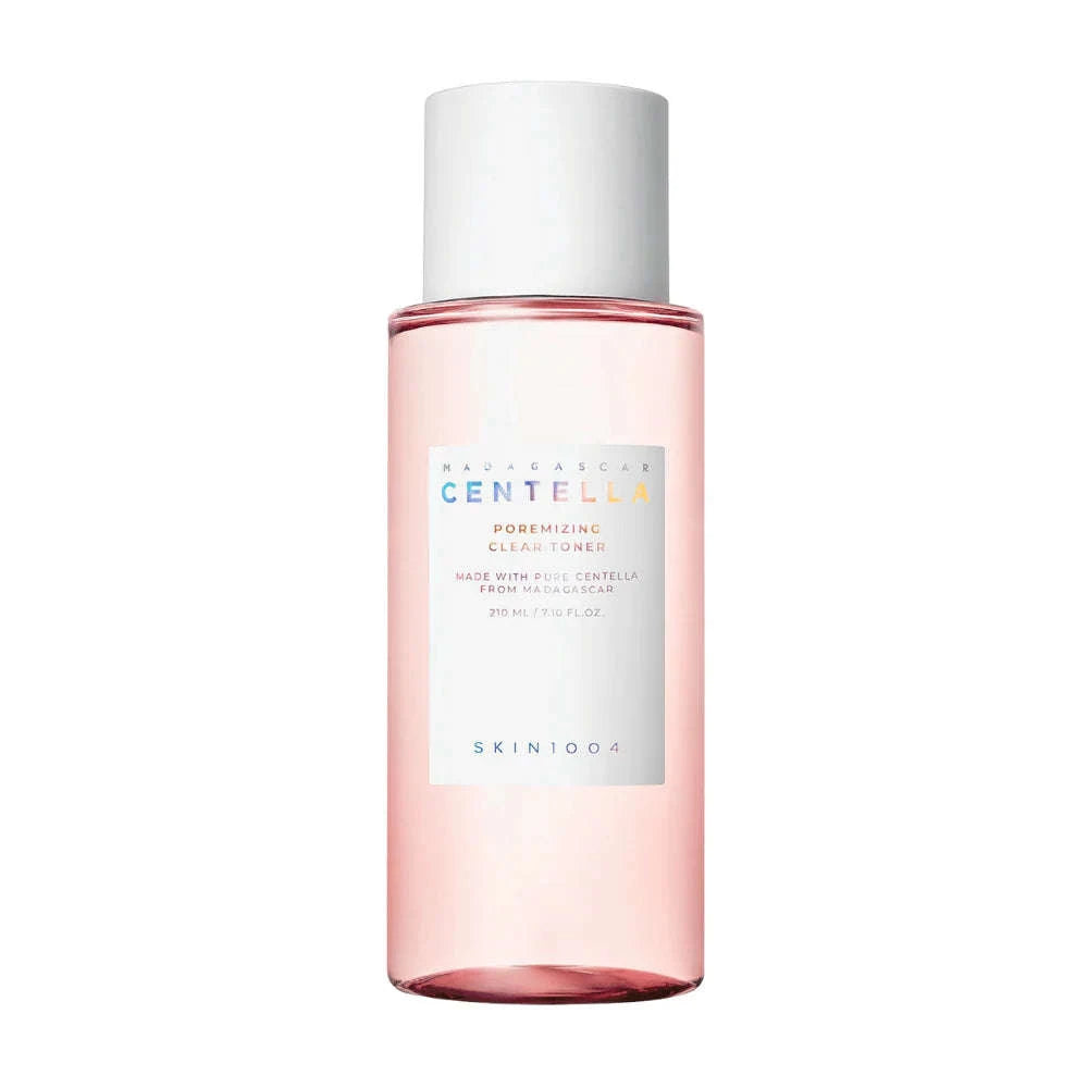 Frasco transparente do SKIN1004 Madagascar Centella Poremizing Clear Toner, com líquido rosa, tampa branca e texto colorido no rótulo a descrever os detalhes do produto. 210ml de tónico facial coreano para minimizar poros