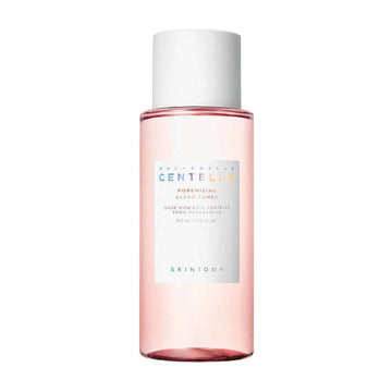 Frasco transparente do SKIN1004 Madagascar Centella Poremizing Clear Toner, com líquido rosa, tampa branca e texto colorido no rótulo a descrever os detalhes do produto. 210ml de tónico facial coreano para minimizar poros