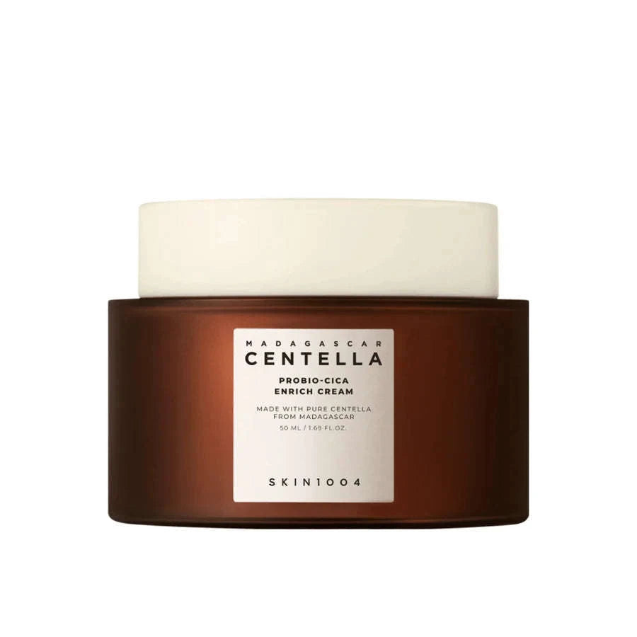 Frasco castanho com a inscrição “Madagascar Centella Probio-Cica Enrich Cream” e tampa branca, destacando o foco em cuidados de pele e ingredientes naturais. Design limpo e minimalista. Skin1004. Glowthie Portugal.