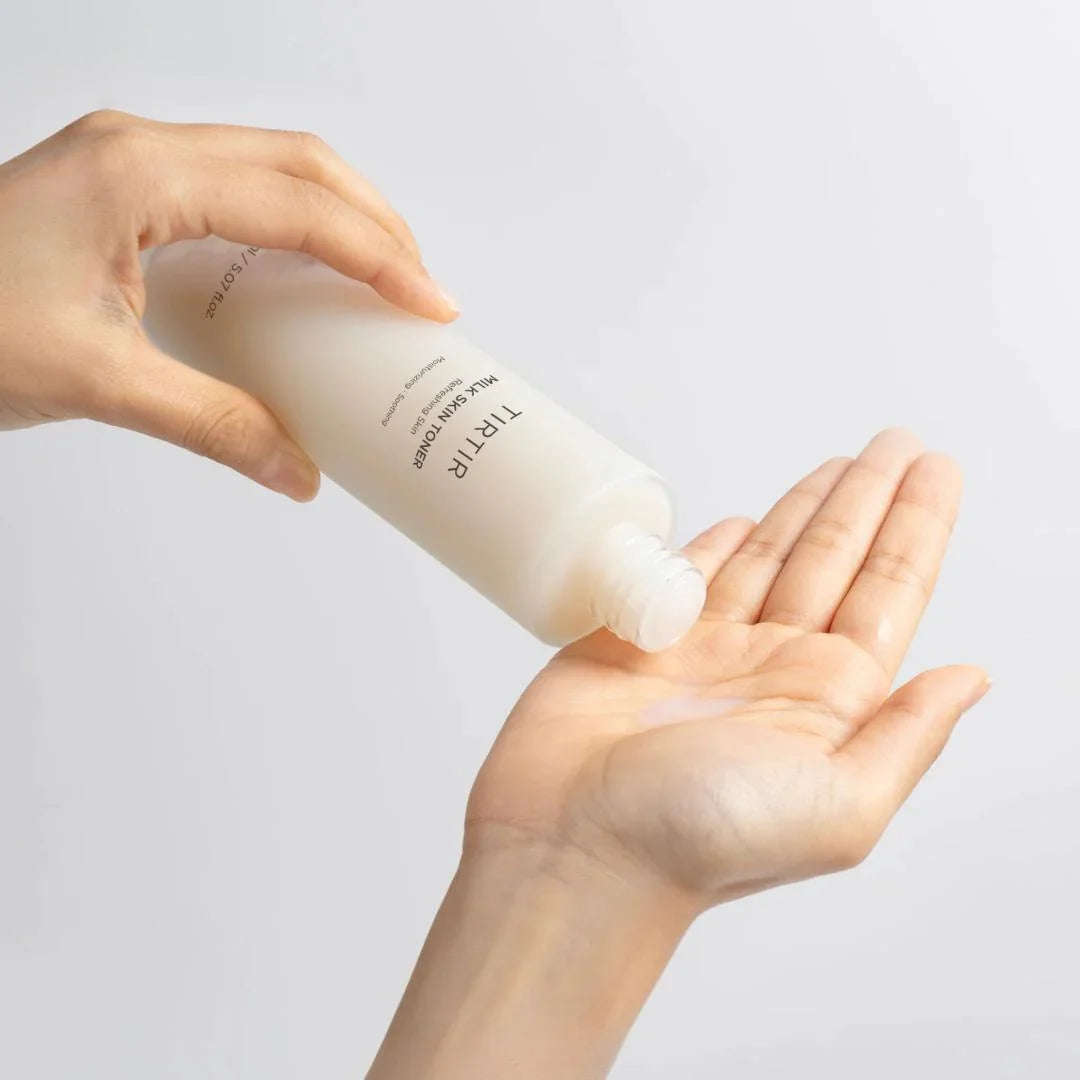 Tônico facial coreano sendo aplicado na mão, embalagem branca, cuidado com a pele K-Beauty.