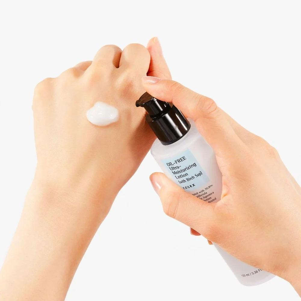 Mãos aplicando loção facial hidratante leve, textura cremosa, produto de cuidado coreano.