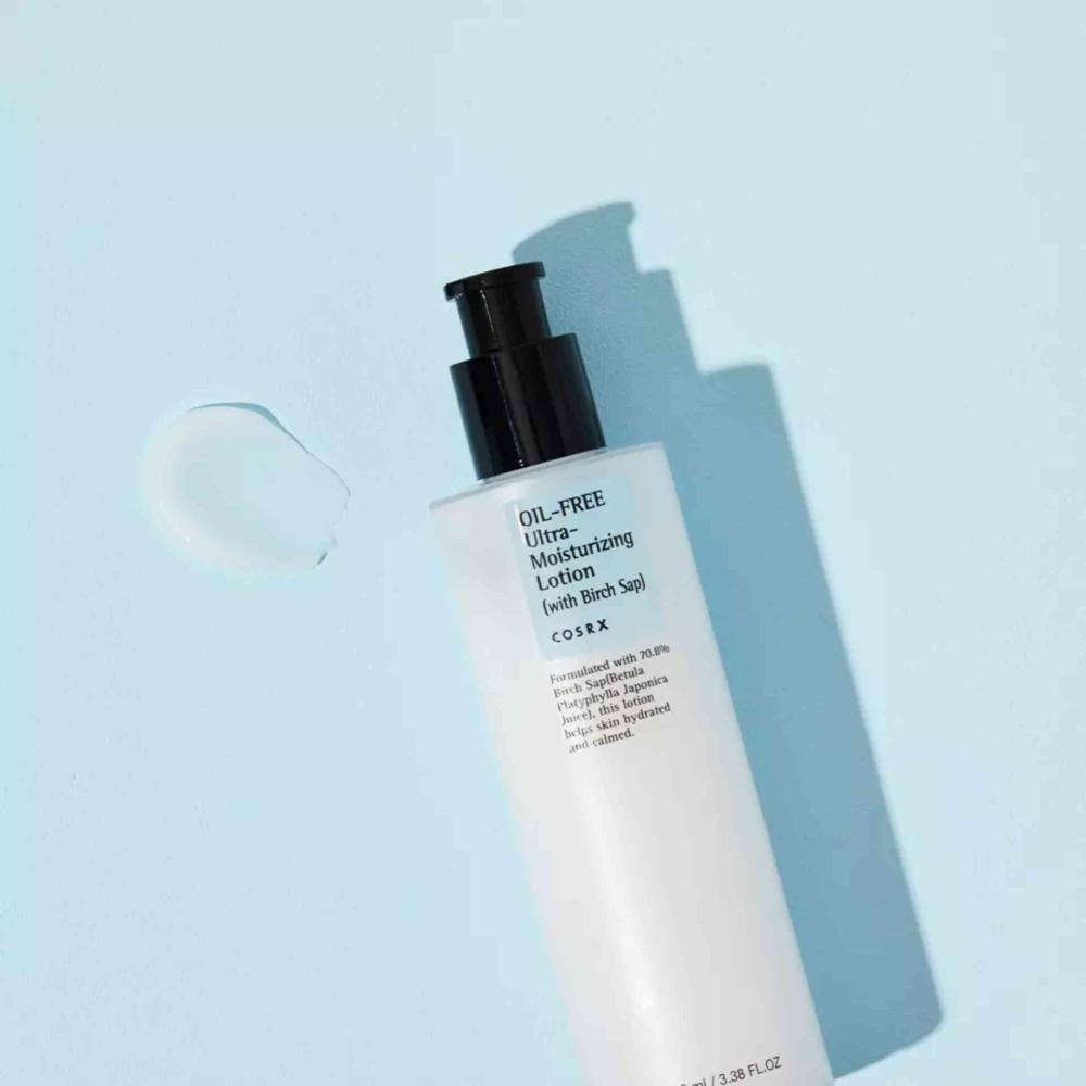 Loção hidratante facial COSRX oil-free sobre fundo azul, ideal para pele oleosa ou sensível.