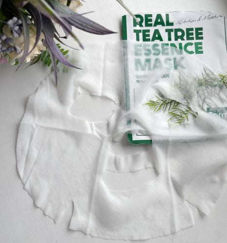Embalagem verde e branca da Farmstay Real Tea Tree Essence Mask, com texto em destaque e ilustração de um ramo de tea tree, transmitindo frescura.